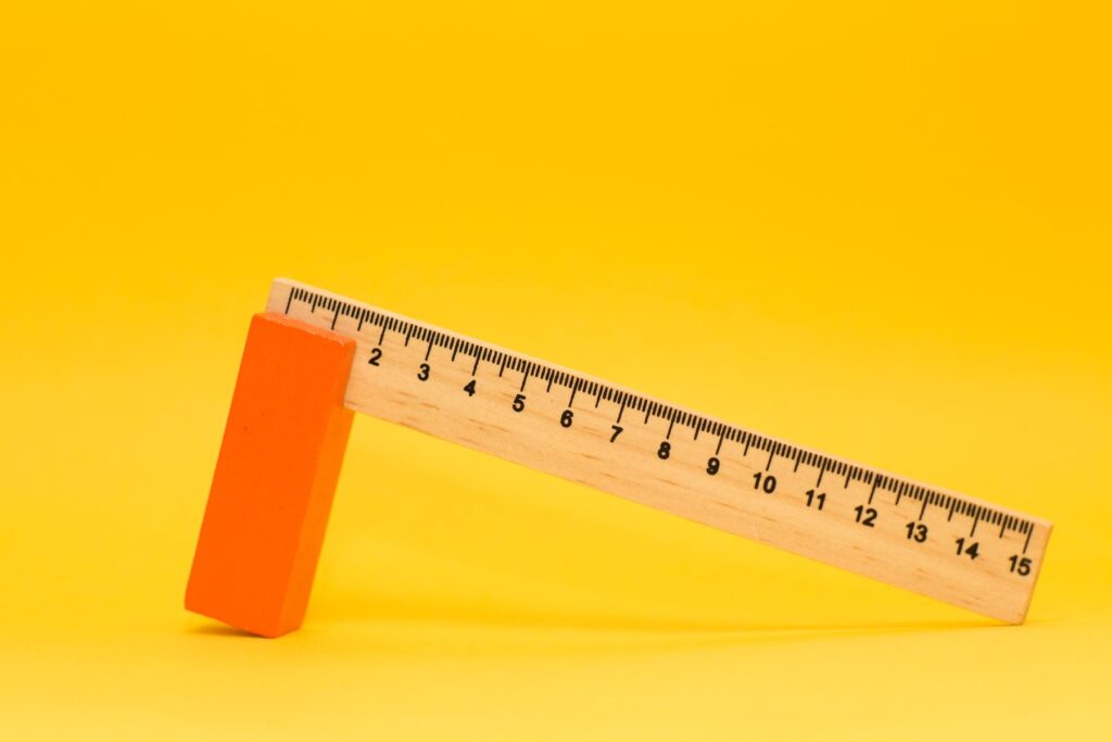 A wooden ruler against yellow background