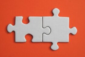 2 jigsaw pieces on an orange table