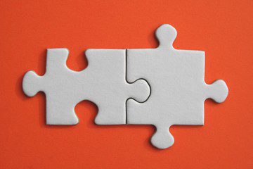 2 jigsaw pieces on an orange table