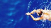 a woman swimming in a deep blue pool