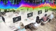 Students at computers with screens that include a representation of a retinal scanner with pixelation and binary data overlays and a brightly coloured datawave heatmap at the top.